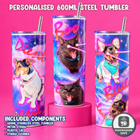 Three personalized 600ml stainless steel tumblers with metal straws are displayed on a bright pink background. The tumblers feature a colorful cosmic design with purple, blue, and pink starry patterns, along with custom pet illustrations of a Jack Russell and a black cat.