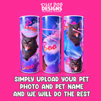 Three cylindrical pet memorial urns with a colorful cosmic cat design, shown on a bright pink background with the brand logo 'SILLY DOG DESIGNS' at the top and promotional text at the bottom.