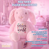 A pink plush bunny toy with long floppy ears and a white belly patch that reads 'Welcome to the world' in script with small heart and star accents. The toy is posed in a pink nursery-like setting with overlaid marketing text, including 'New Baby Plush Collection' and product details.